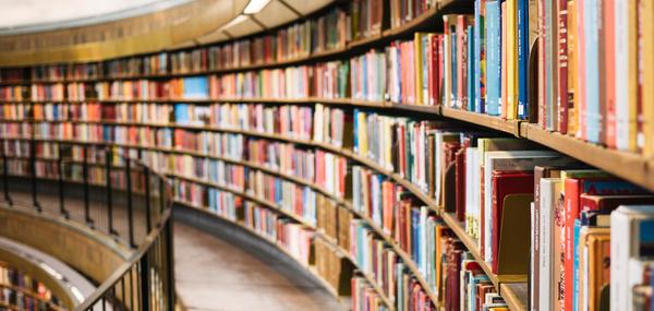 books on long curved library bookshelves (c) Susan Yin unsplash 